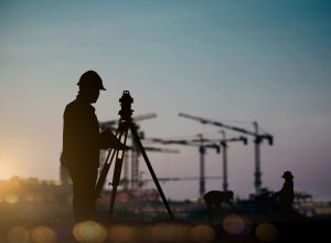 silhouette engineer looking Loaders and trucks in a building site over Blurred construction worker on construction site